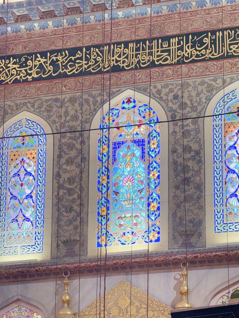 Stained glass windows and calligraphy inside the Blue Mosque