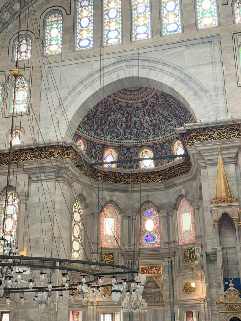 Ornate arches and stained glass inside Nuruosmaniye Mosque, architectural highlight of Istanbul itinerary